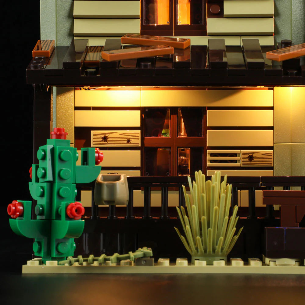 Lumibricks F9021 Western Saloon exterior with illuminated windows, green cactus, rustic porch, and desert landscaping
