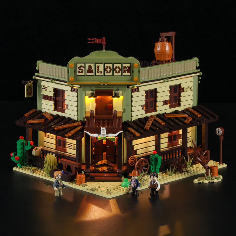 Lumibricks F9021 Western Saloon illuminated at night, corner view with glowing porch, minifigures, cacti, and rustic Western details
