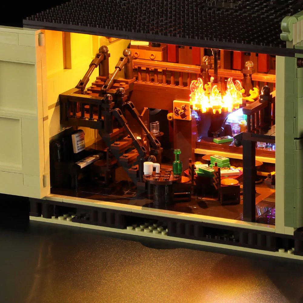 Lumibricks F9021 Western Saloon interior cutaway showing glowing chandelier, staircase, tables, and rustic Western decor