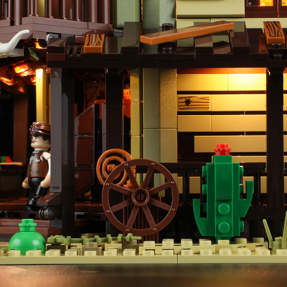 Lumibricks F9021 Western Saloon porch with illuminated windows, wagon wheel, cactus, and cowboy minifigure at swinging doors