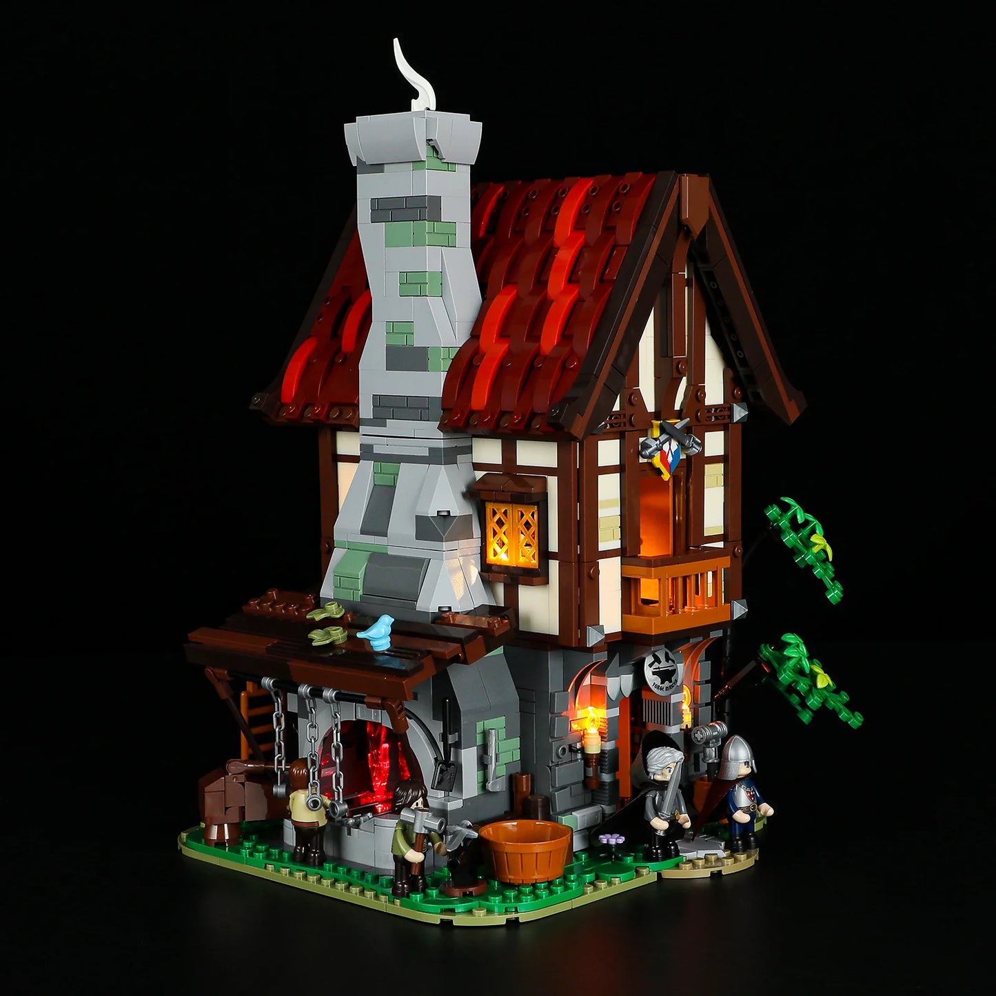 Lumibricks F9040 Forge House at night with illuminated windows, glowing forge, minifigures, and medieval workshop details