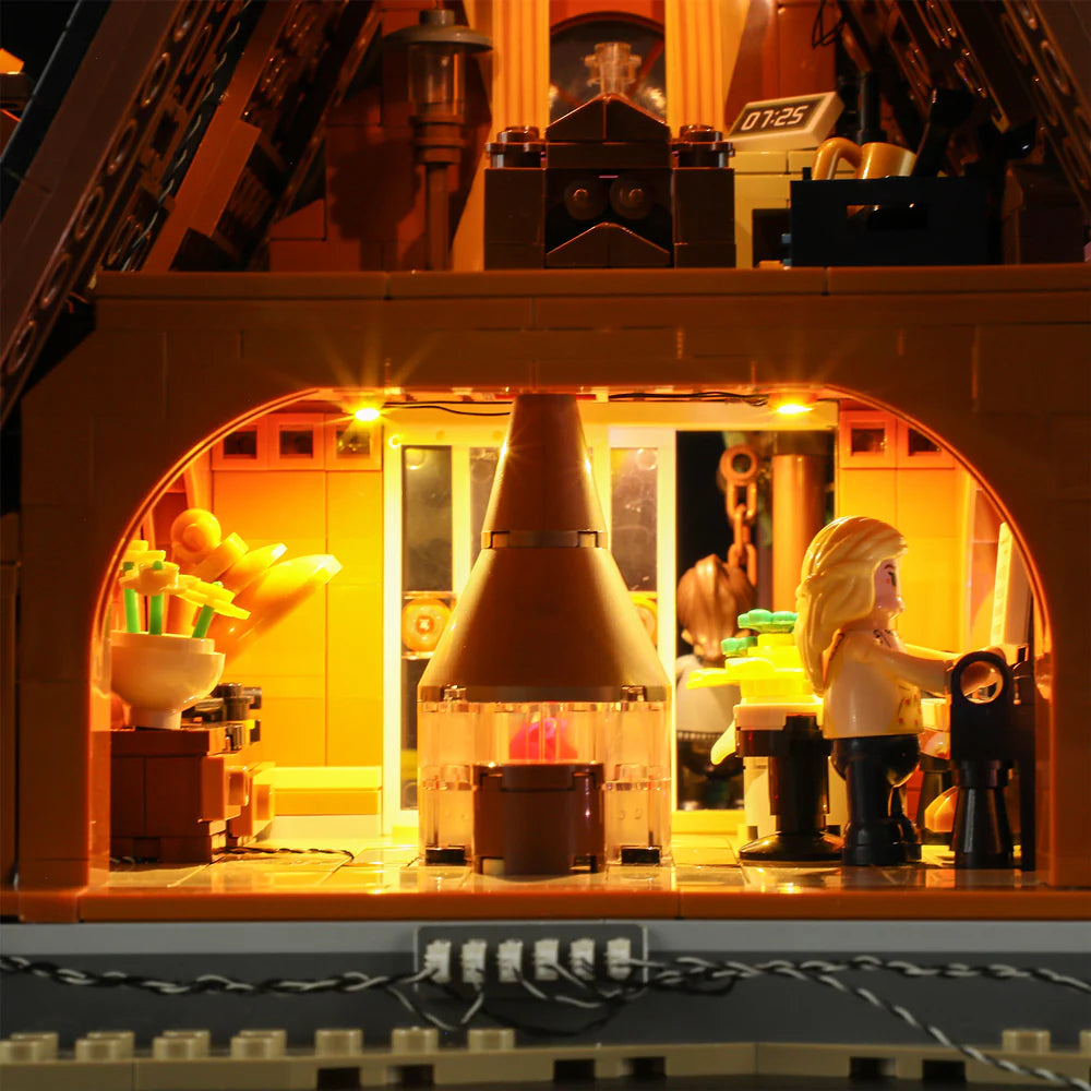 Funwhole A-Frame Cabin LEGO set interior with glowing fireplace, detailed kitchen, and cozy cabin atmosphere at night