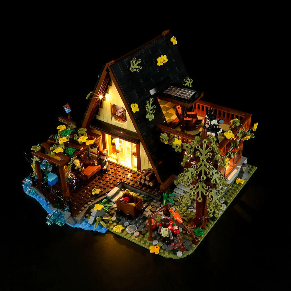 Funwhole A-Frame Cabin LEGO set with warm lighting, detailed outdoor scenery, minifigures, and nature elements at night