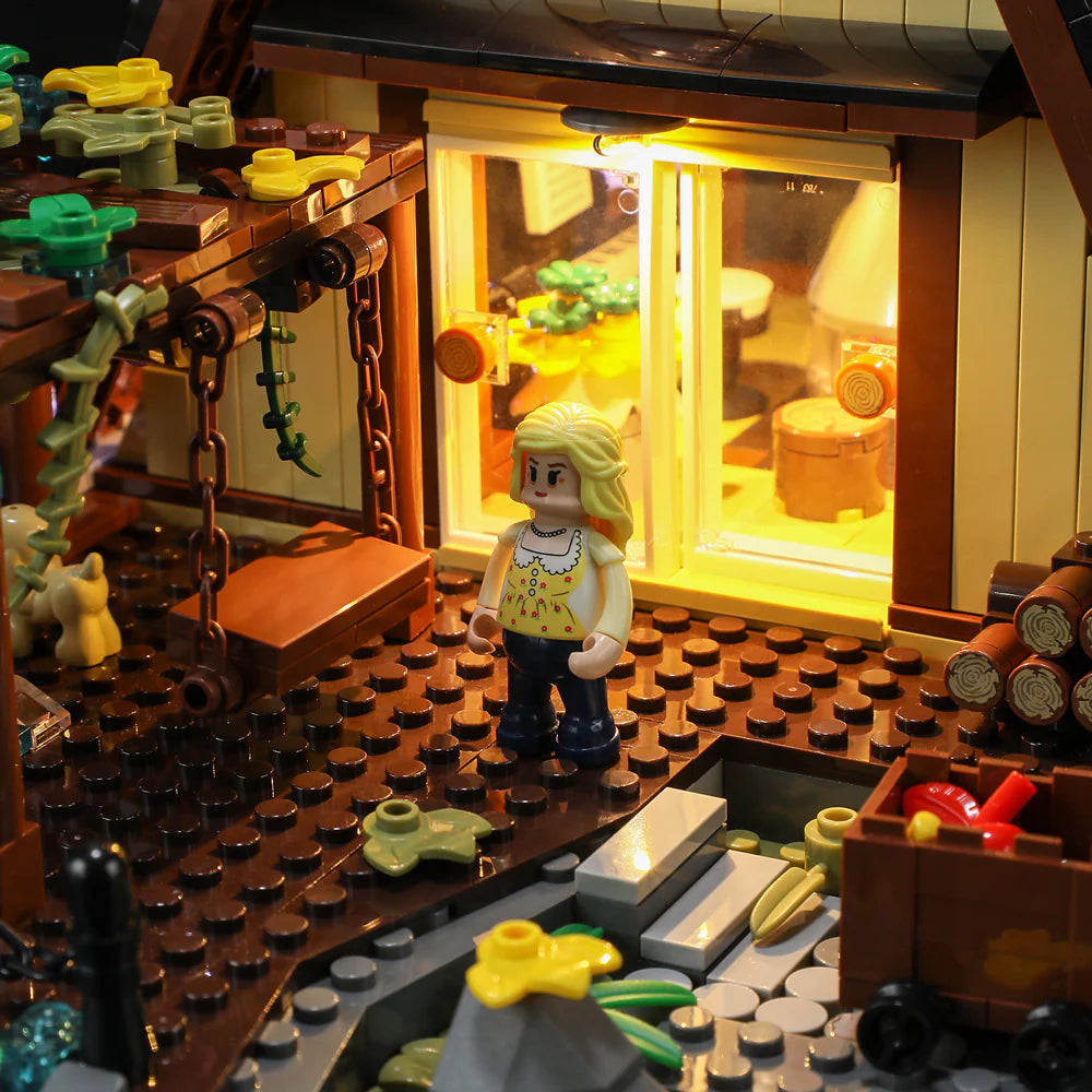 Funwhole A-Frame Cabin set featuring a cozy porch scene with a minifigure, wooden swing, and illuminated interior view