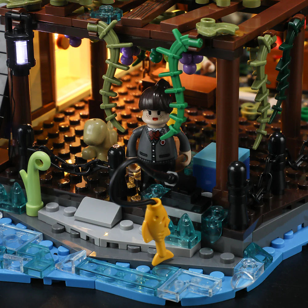 Funwhole A-Frame Cabin set featuring a riverside fishing scene with a minifigure, fishing rod, and scenic pergola