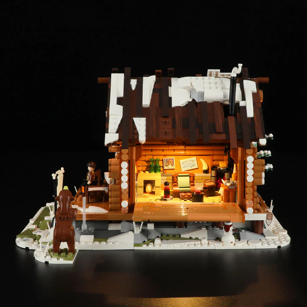 Back view of Funwhole Hunting Cabin set with LED-lit interior, cozy furniture, snowy roof, and a bear figure in a winter scene