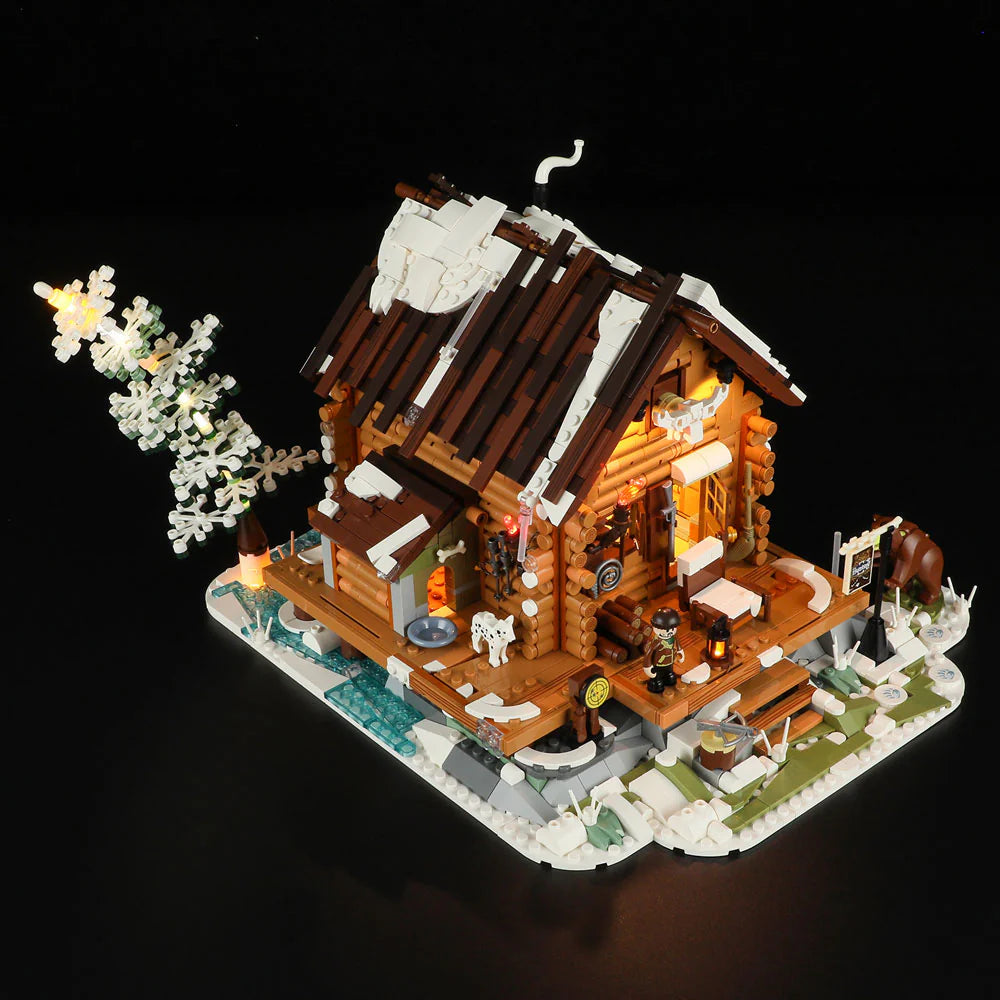 Top view of Funwhole Hunting Cabin set with LED lights, snowy roof, wooden details, and winter scenery featuring a bear