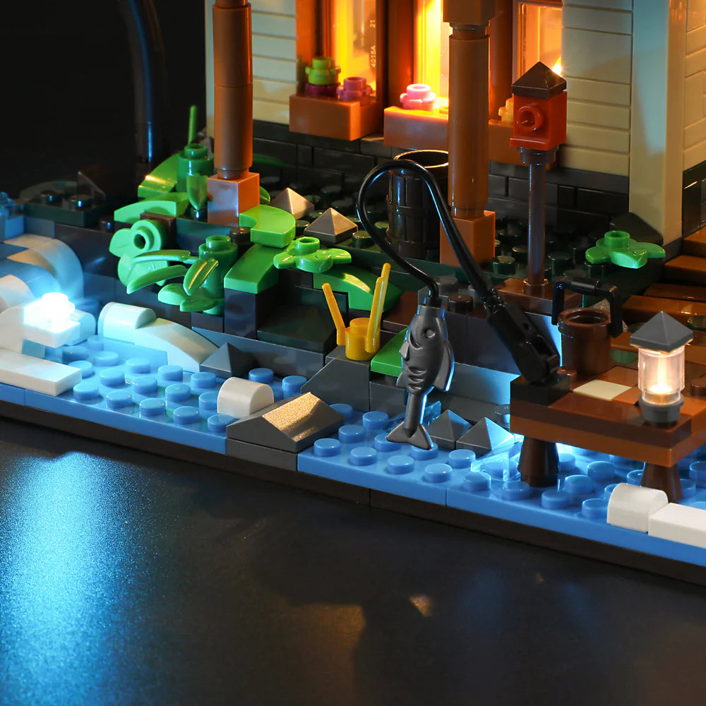 Close-up of Funwhole Lakeside Lodge set featuring a fishing spot with a hanging fish, dock, glowing water, and lush greenery