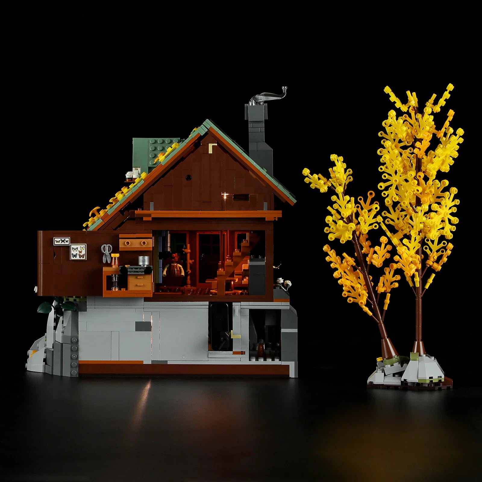 Funwhole Mountain Cabin – Detailed cutaway view showcasing interior rooms, lighting, and autumn tree in LEGO adventure set