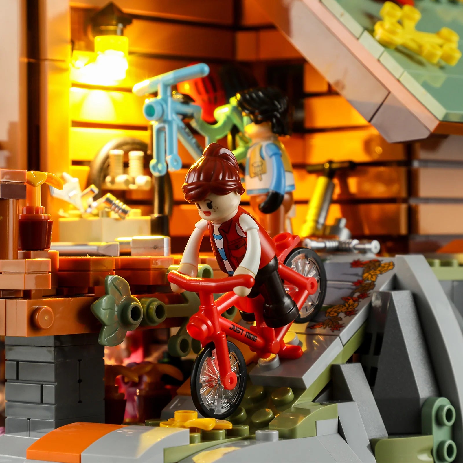Funwhole Mountain Cabin – Minifigure riding a red bike down a rocky slope, with a workshop and repair tools in the background