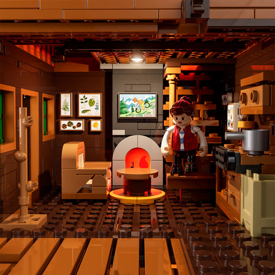 Funwhole Mountain Cabin – Cozy LEGO cabin interior with a fireplace, framed art, and a minifigure in a warm rustic setting