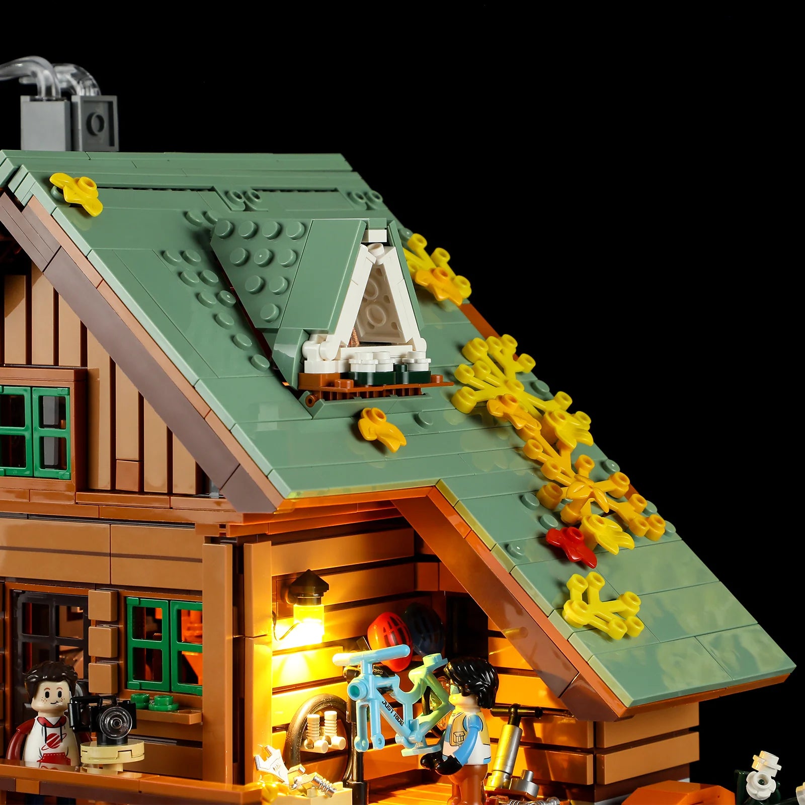 Funwhole Mountain Cabin – Close-up of green sloped roof with dormer, autumn leaves, and balcony bike repair area in LEGO set