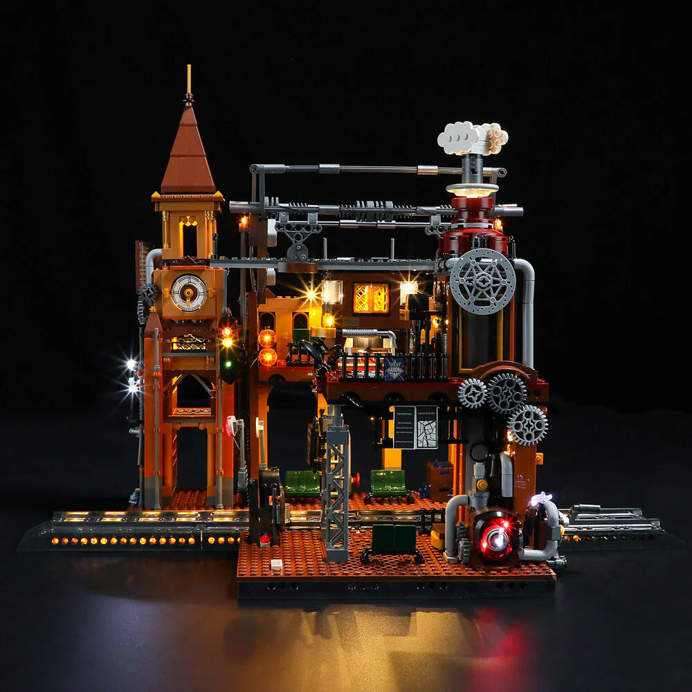 Lumibricks F9007 Steampunk Train Station front view at night with illuminated clock tower, gears, and platform