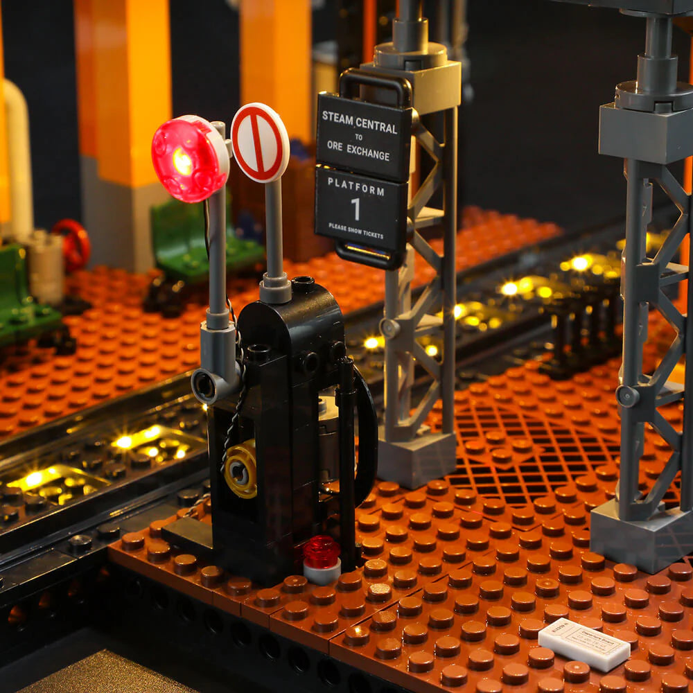 Lumibricks F9007 Steampunk Train Station platform with traffic lights, station sign, and illuminated tracks at night