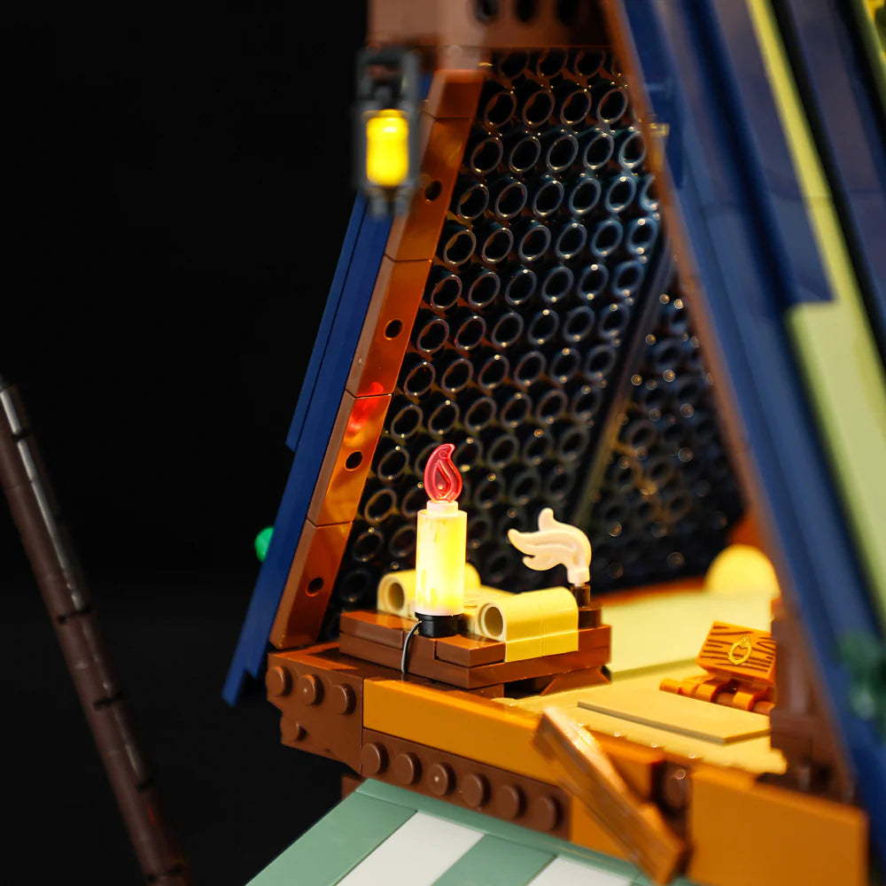Lumibricks F9011 Medieval Pier Inn attic detail with glowing candle, scrolls, and illuminated window at night
