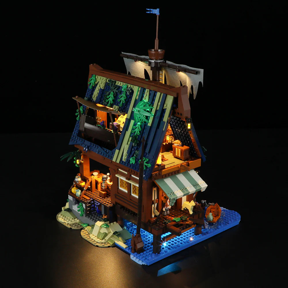 Lumibricks F9011 Medieval Pier Inn front angle at night with glowing LED lights, detailed roof, and illuminated pier