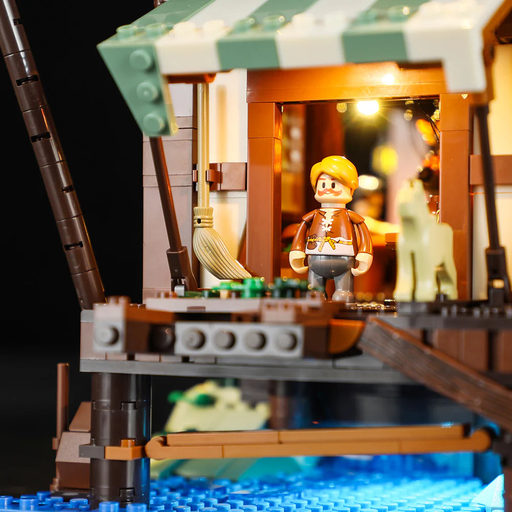 Lumibricks F9011 Medieval Pier Inn market entrance with minifigure, dog, green awning, and glowing interior lights