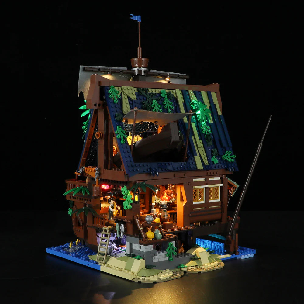 Lumibricks F9011 Medieval Pier Inn backyard at night with glowing lights, stone steps, cooking area, and water details