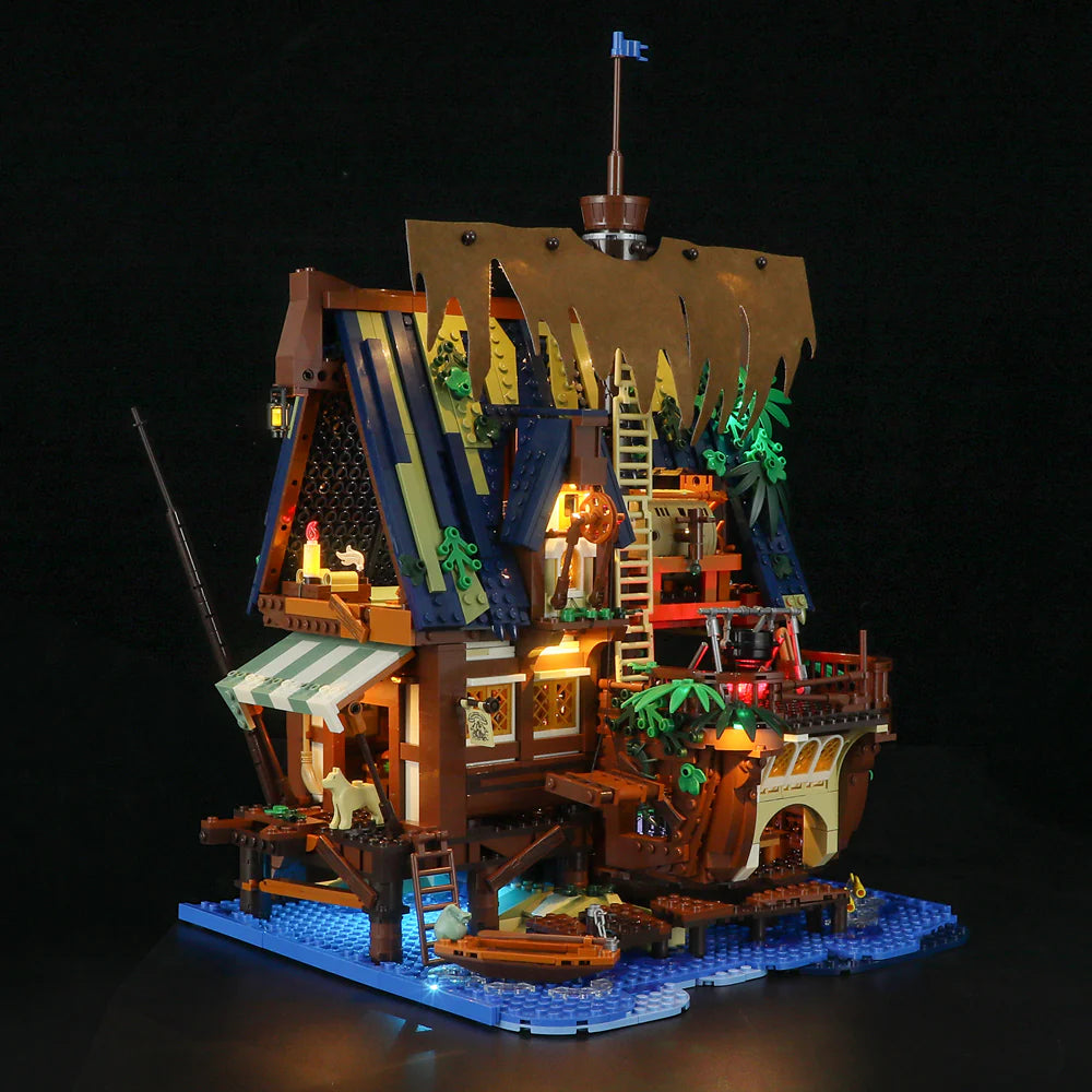Lumibricks F9011 Medieval Pier Inn front view at night with glowing LED lights, detailed roof, and lively harbor scene