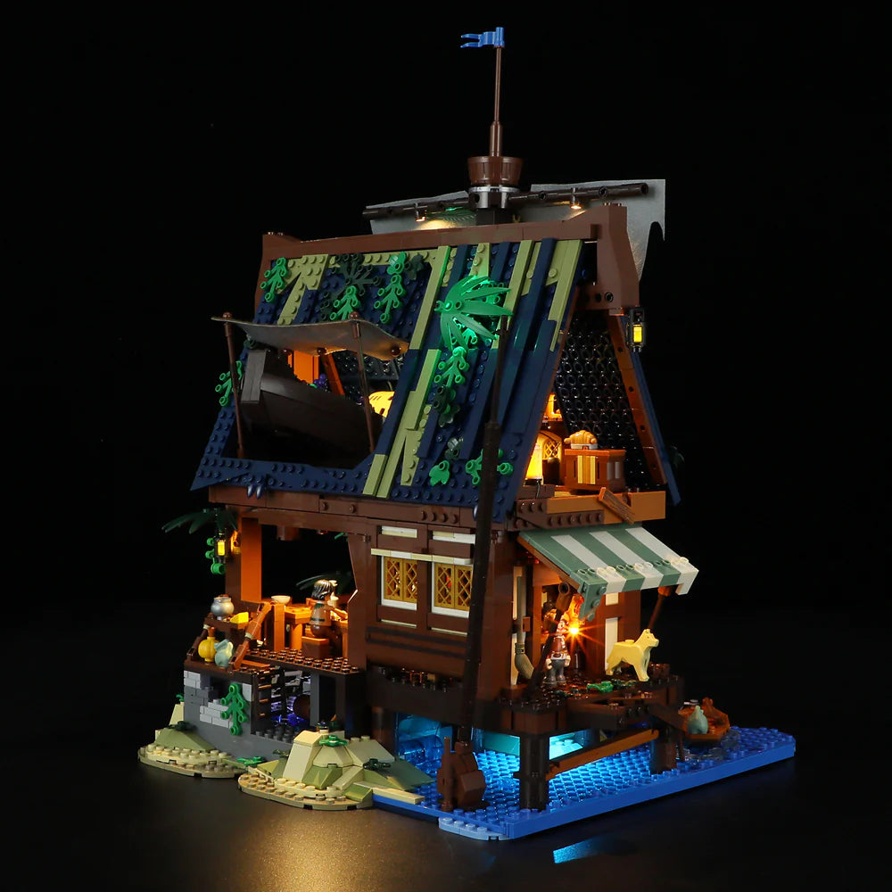 Lumibricks F9011 Medieval Pier Inn rear and side view at night with illuminated windows, boat, and medieval accessories