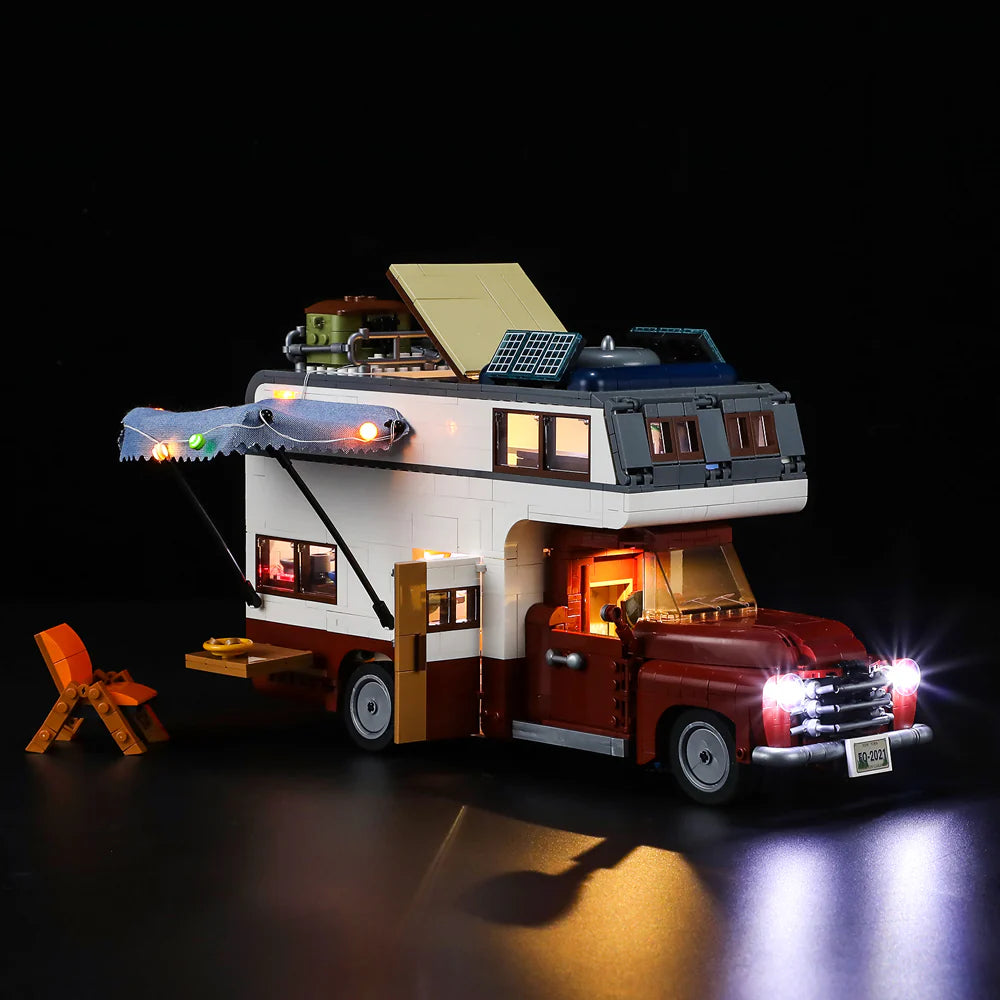 Lumibricks F9012 Camper Van at night with illuminated awning, glowing headlights, and open side door