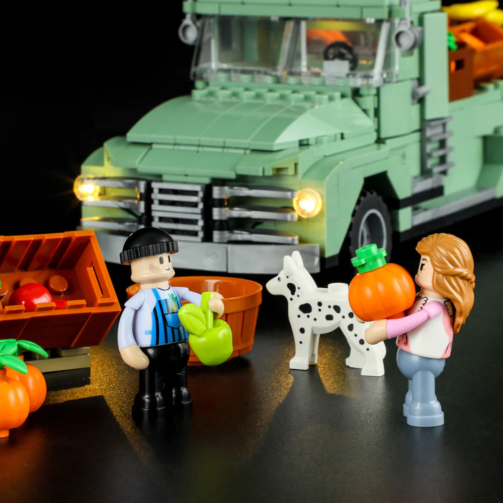 Lumibricks F9016 Farm Truck with headlights on, market stand, minifigures, dog, and pumpkins at night