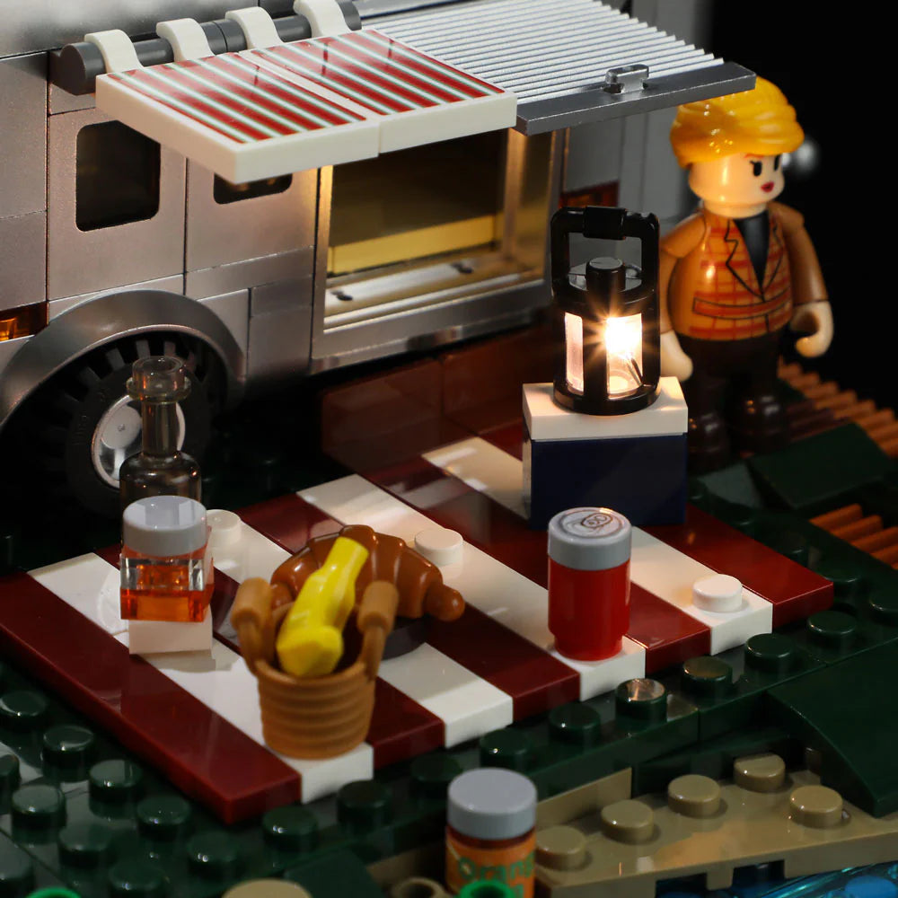 Lumibricks F9022 Lookout Campground camper van with striped awning, picnic setup, glowing lantern, food, and minifigure