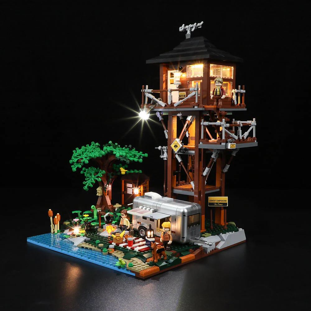 Lumibricks F9022 Lookout Campground at night with LED lights, illuminated lookout tower, camper, campfire, tree, and minifigures