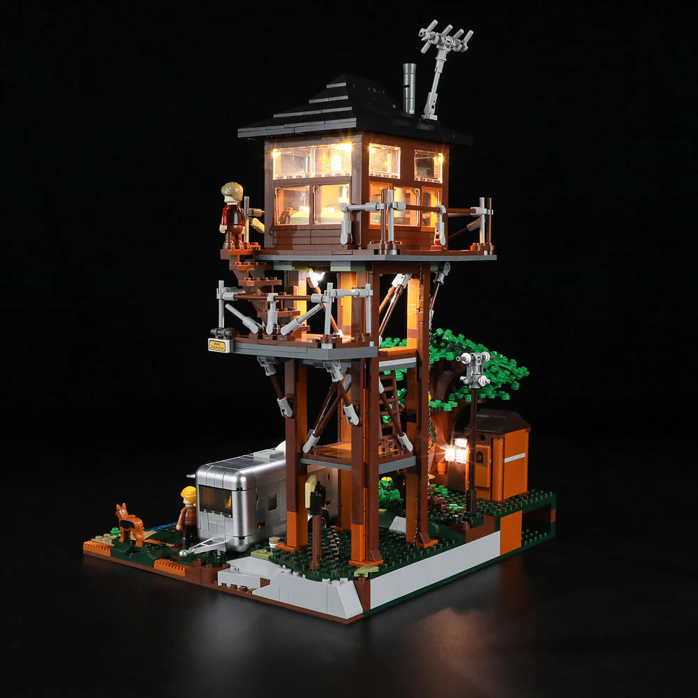 Lumibricks F9022 Lookout Campground illuminated lookout tower at night with minifigure, camper trailer, and trees