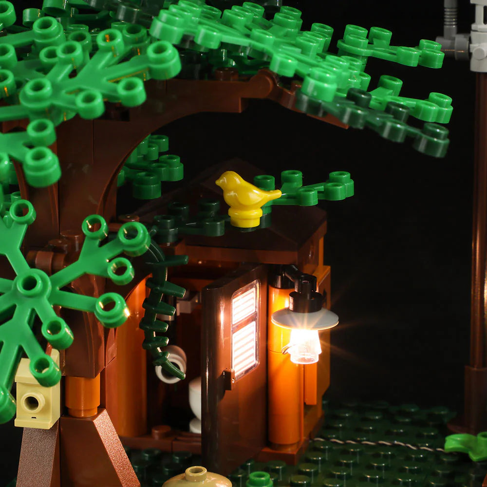 Lumibricks F9022 Lookout Campground close-up of tree, outhouse with light, and yellow bird on branch