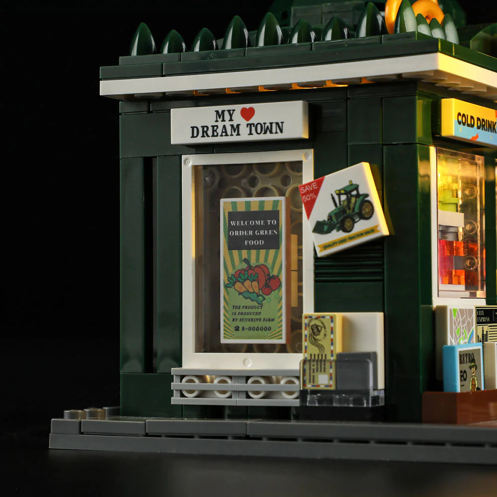 Lumibricks F9023 Newsstand "My Dream Town" window with green food poster, tractor ad, and cold drink fridge lit at night