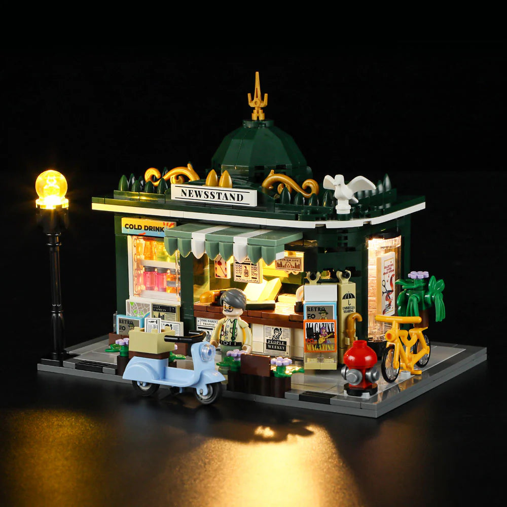 Lumibricks F9023 Newsstand front view at night with glowing street lamp, minifigure vendor, and detailed city accessories