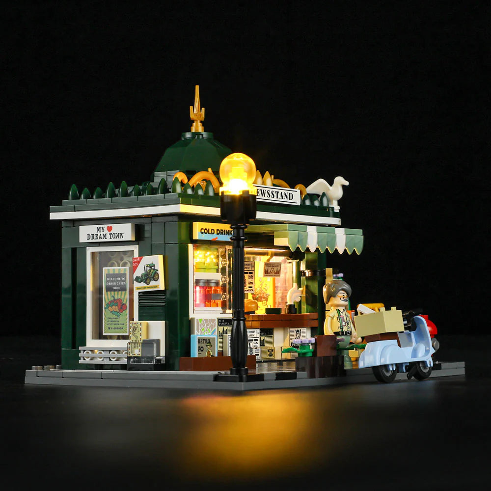 Lumibricks F9023 Newsstand side angle at night with illuminated lamp post, newsstand details, and blue scooter in front