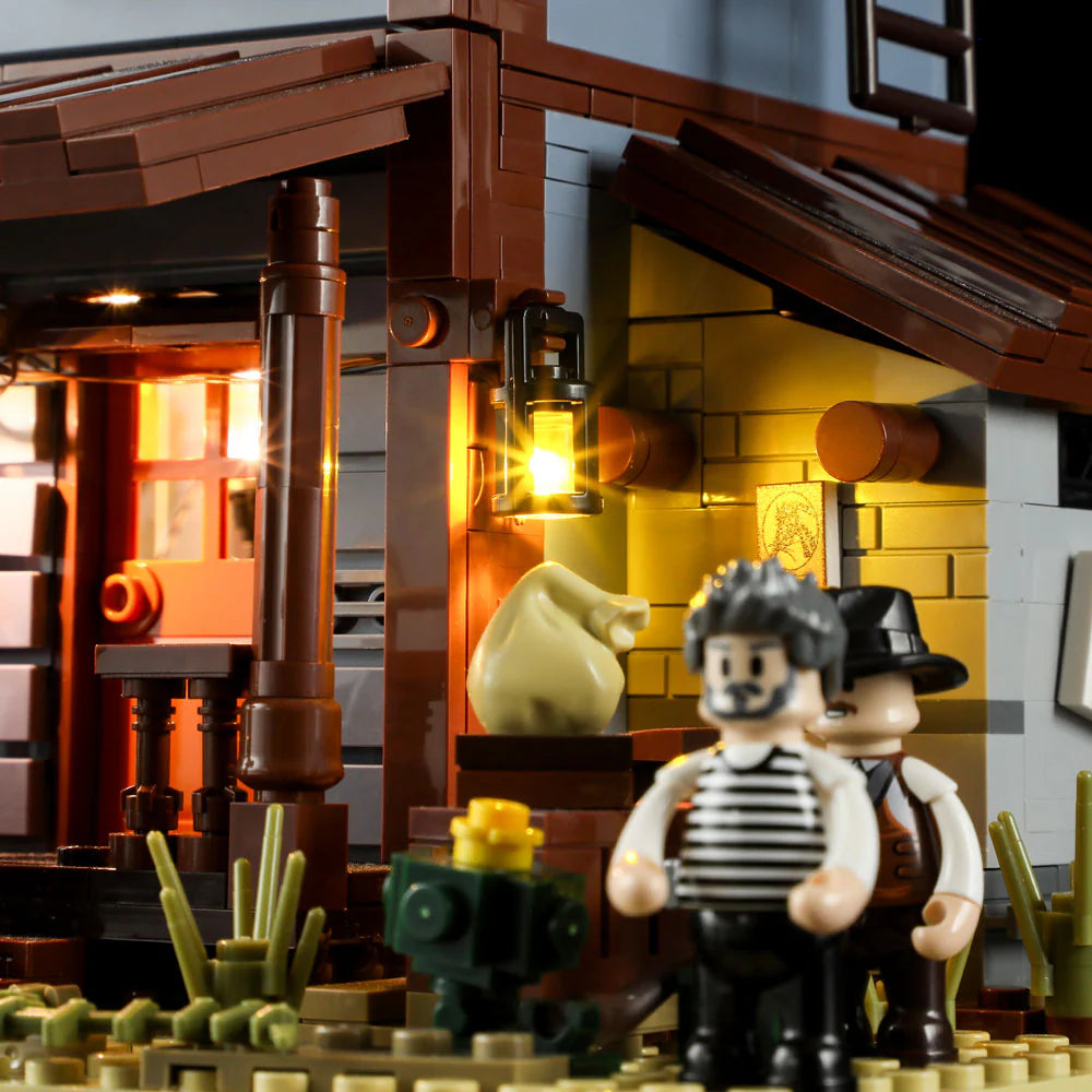 Lumibricks F9026 Sheriff’s Office porch close-up with glowing lantern, bandit minifigures, money bag, and wanted poster at night