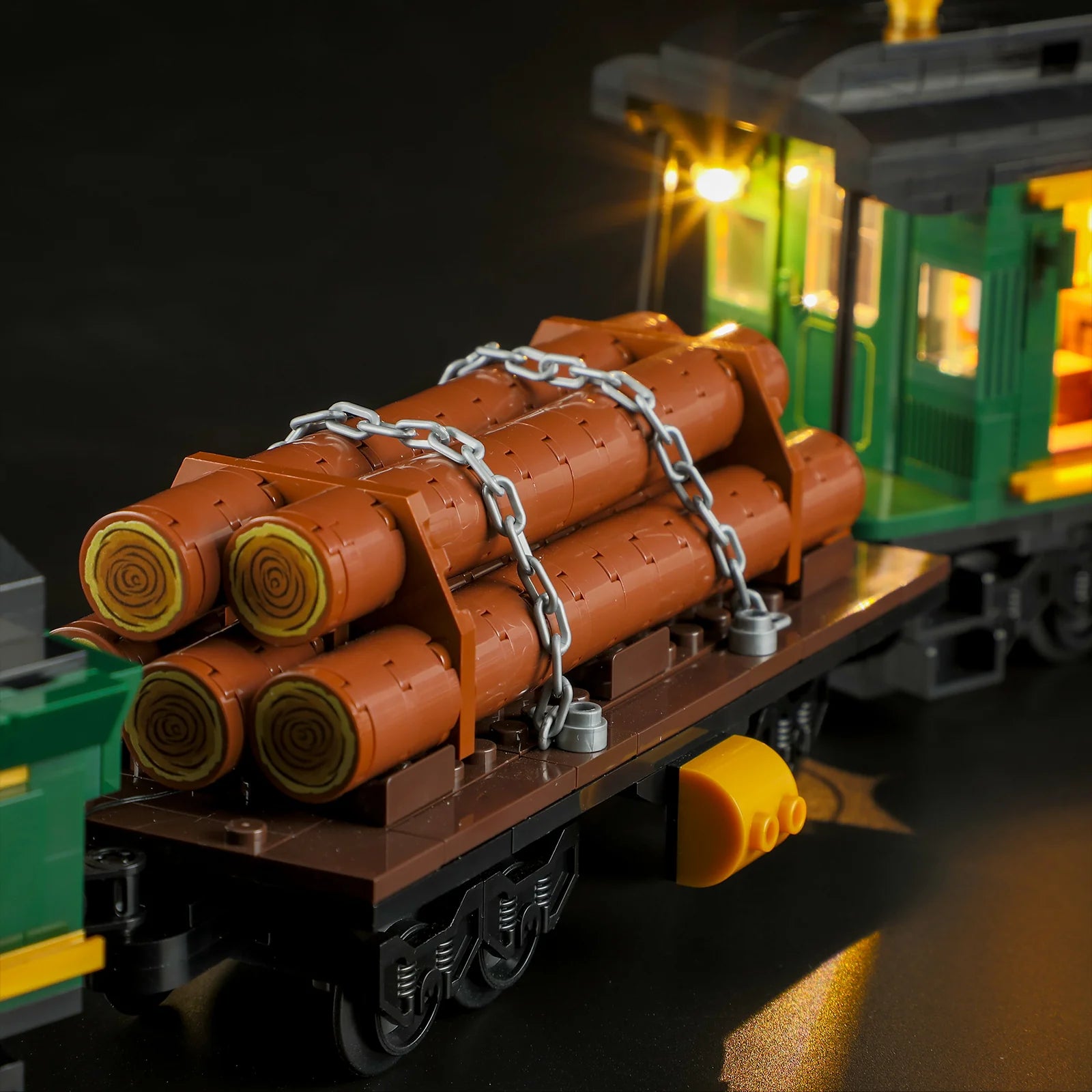 Lumibricks (Formerly Funwhole) F9036 Western Freight Train log car with stacked logs, chains, and illuminated cab in the background