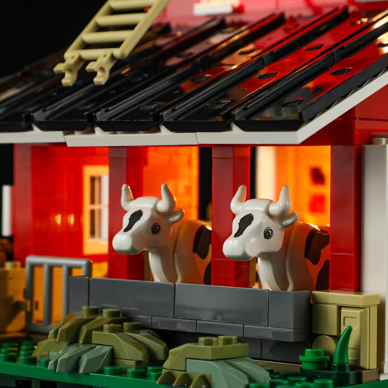 Lumibricks F9037 Cow Barn exterior with two cows in stalls, glowing barn interior, black roof panels, and tan ladder detail