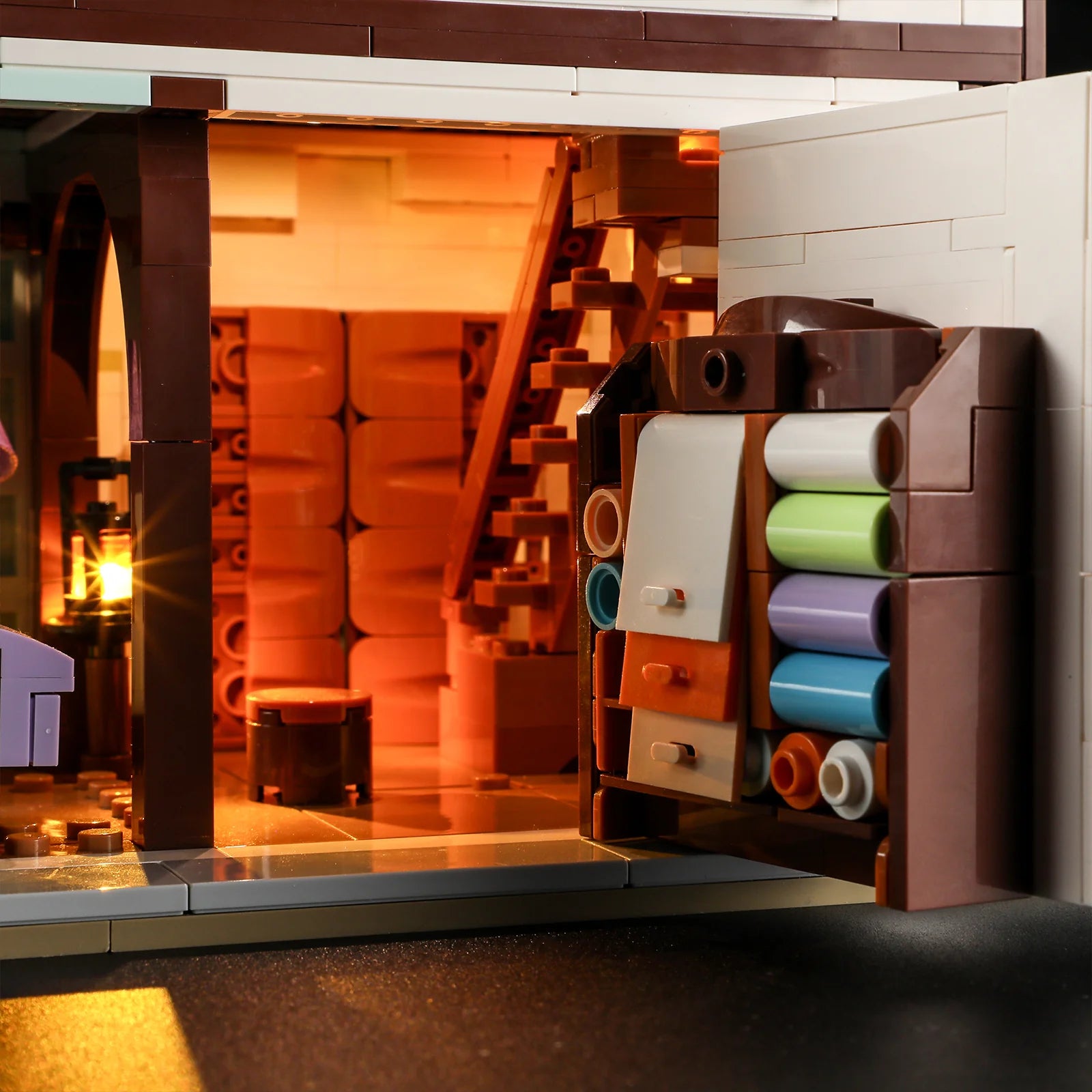 Lumibricks F9038 Medieval Tailor Shop close-up of illuminated fabric cabinet with colorful rolls and storage drawers
