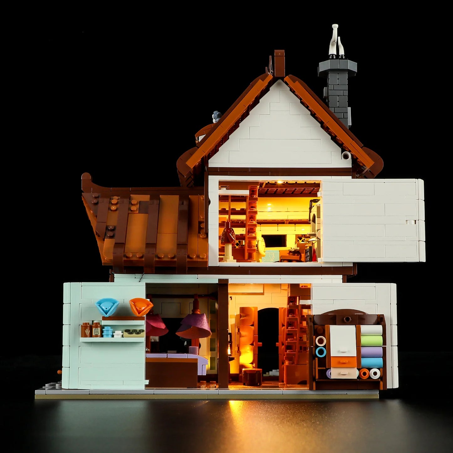 Lumibricks F9038 Medieval Tailor Shop interior cross-section showing lit workshop, fabric shelves, and cozy living space