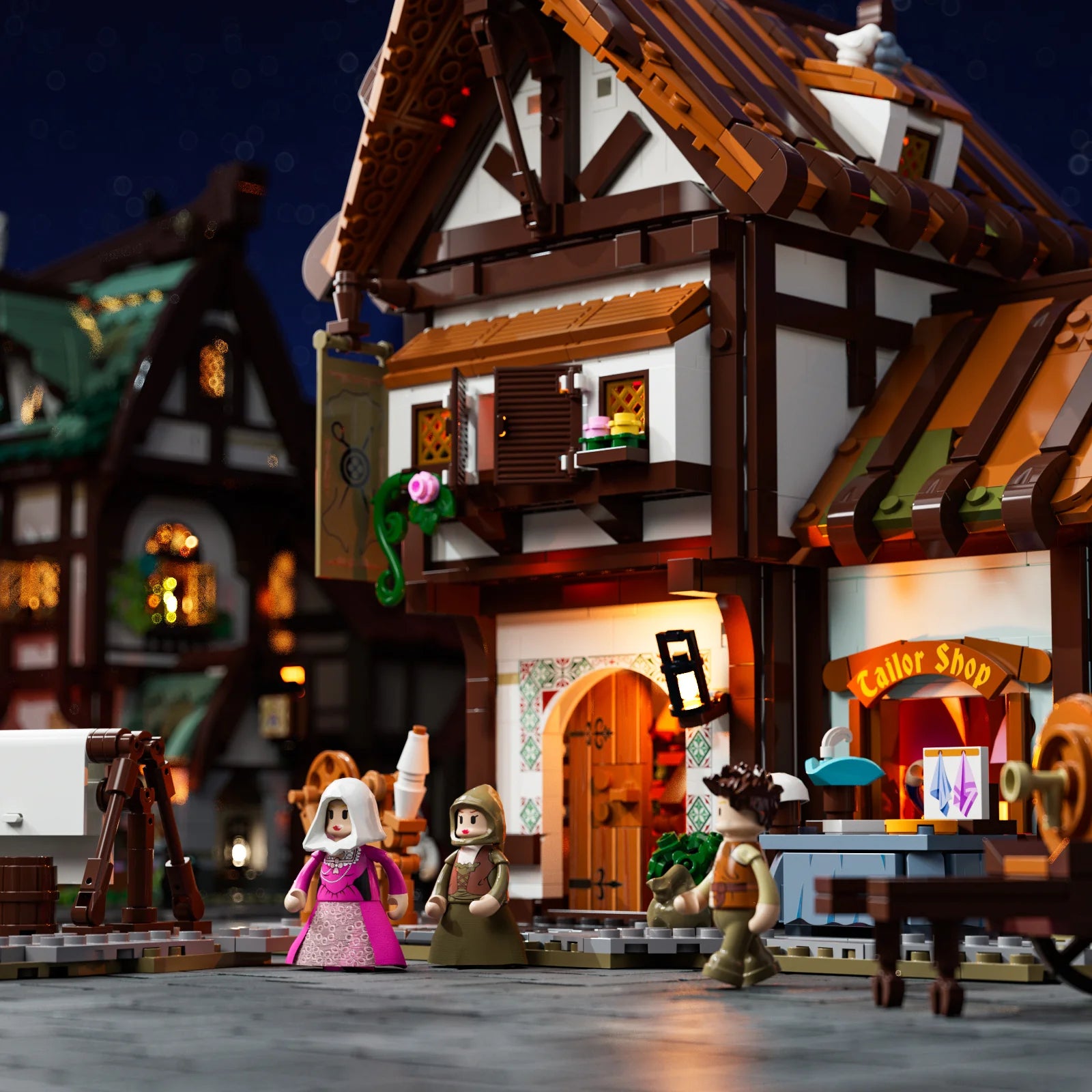 Lumibricks F9038 Medieval Tailor Shop at night with illuminated windows, market stall, and medieval minifigures outside
