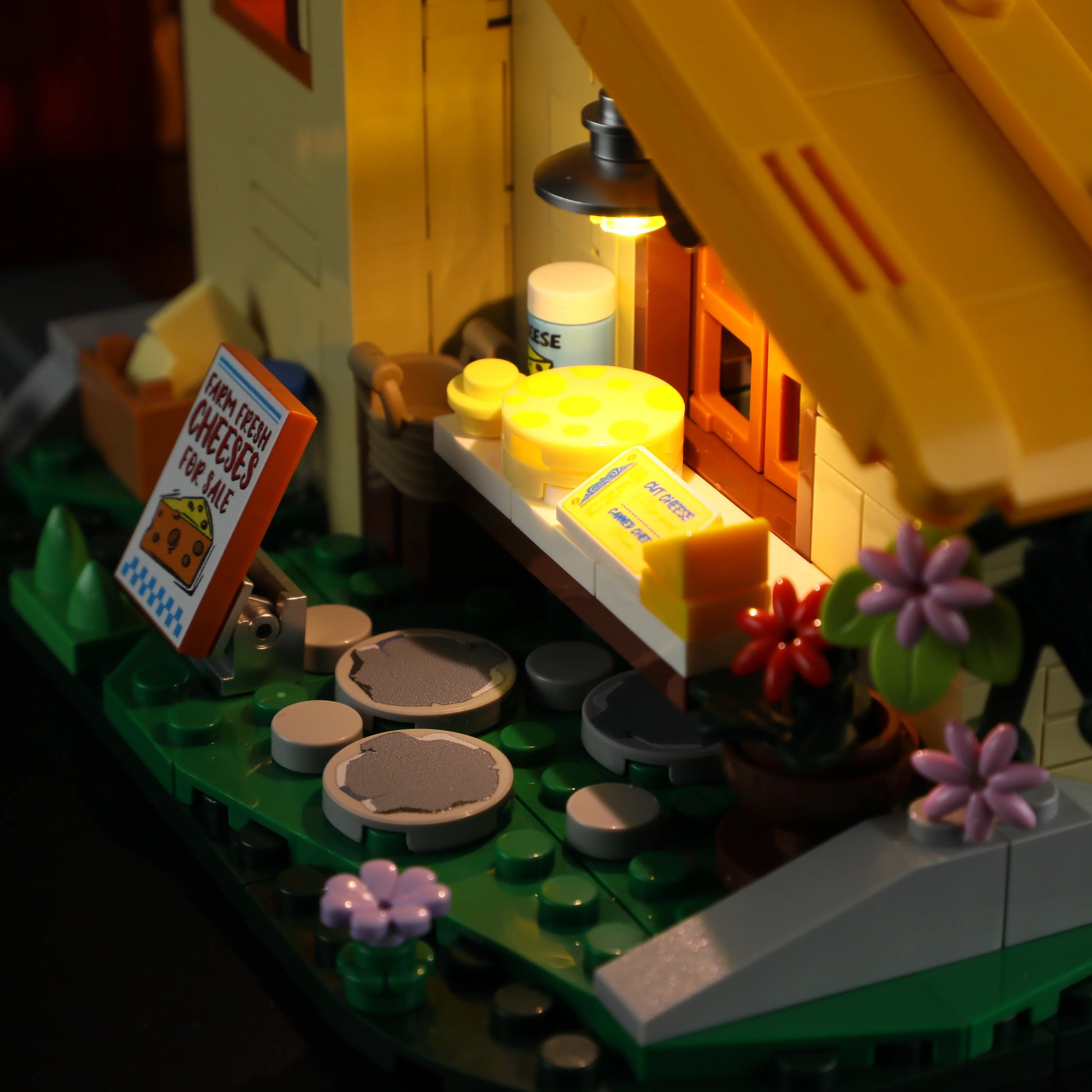 Lumibricks (Formerly Funwhole) F9049 Farm Cheese House cheese stand with wheels, butter, flowers, and illuminated porch