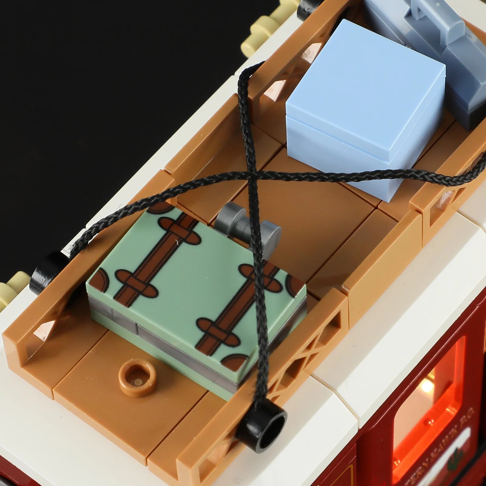 Lumibricks F9052 Western Stagecoach rooftop luggage area with suitcase, parcels, rope, and glowing lantern