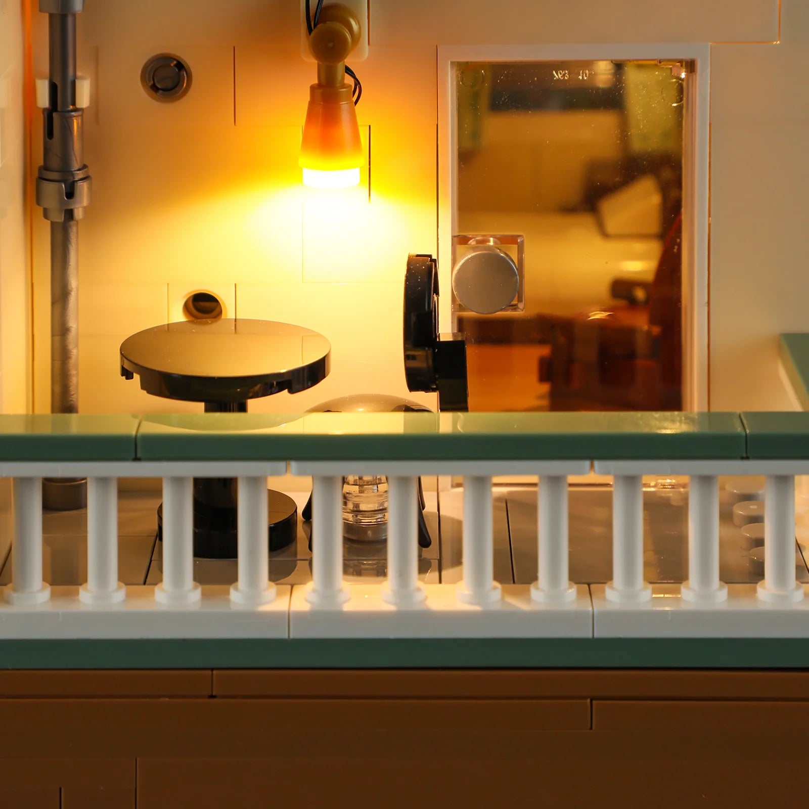 Lumibricks (Formerly Funwhole) F9054 Twilight Motel balcony with round table, glowing lamp, and window view into motel room