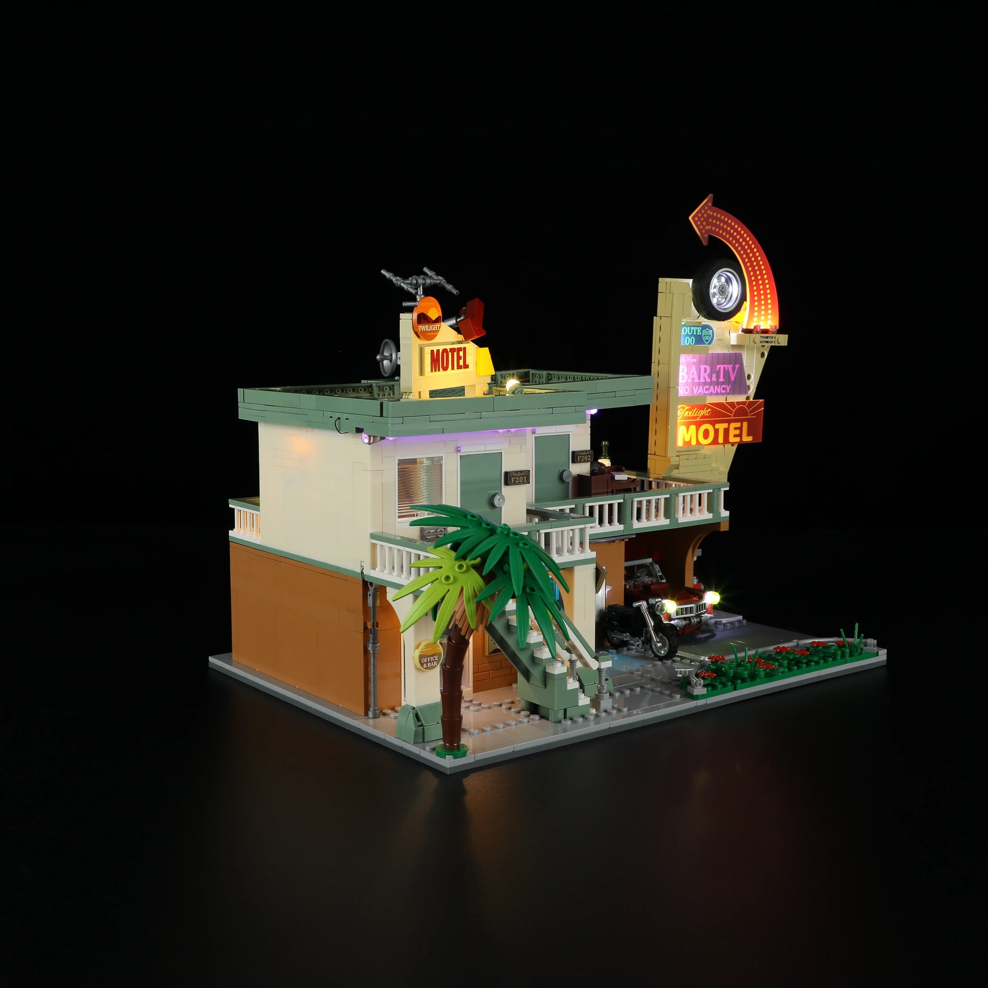 Lumibricks (Formerly Funwhole) F9054 Twilight Motel side view at night with illuminated rooms, palm tree, and neon motel sign