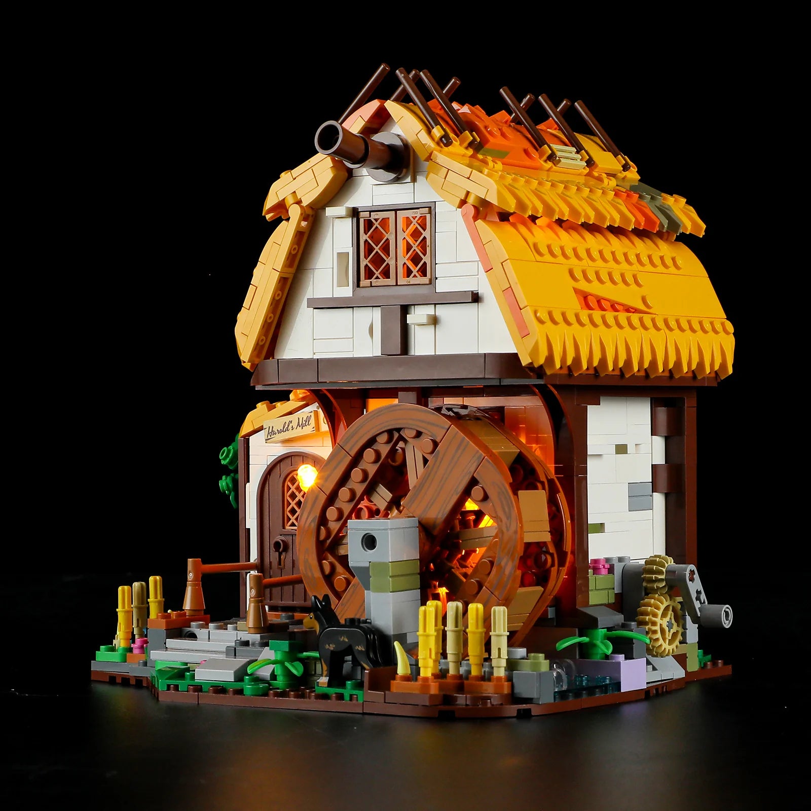 Lumibricks (Formerly Funwhole) F9061 Medieval Water Mill at night with glowing LED lights, working waterwheel, and rustic details
