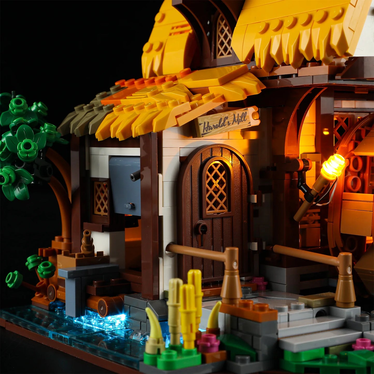 Lumibricks (Formerly Funwhole) F9061 Medieval Water Mill exterior with Harold’s Mill sign, glowing lantern, blue-lit stream, and rustic door