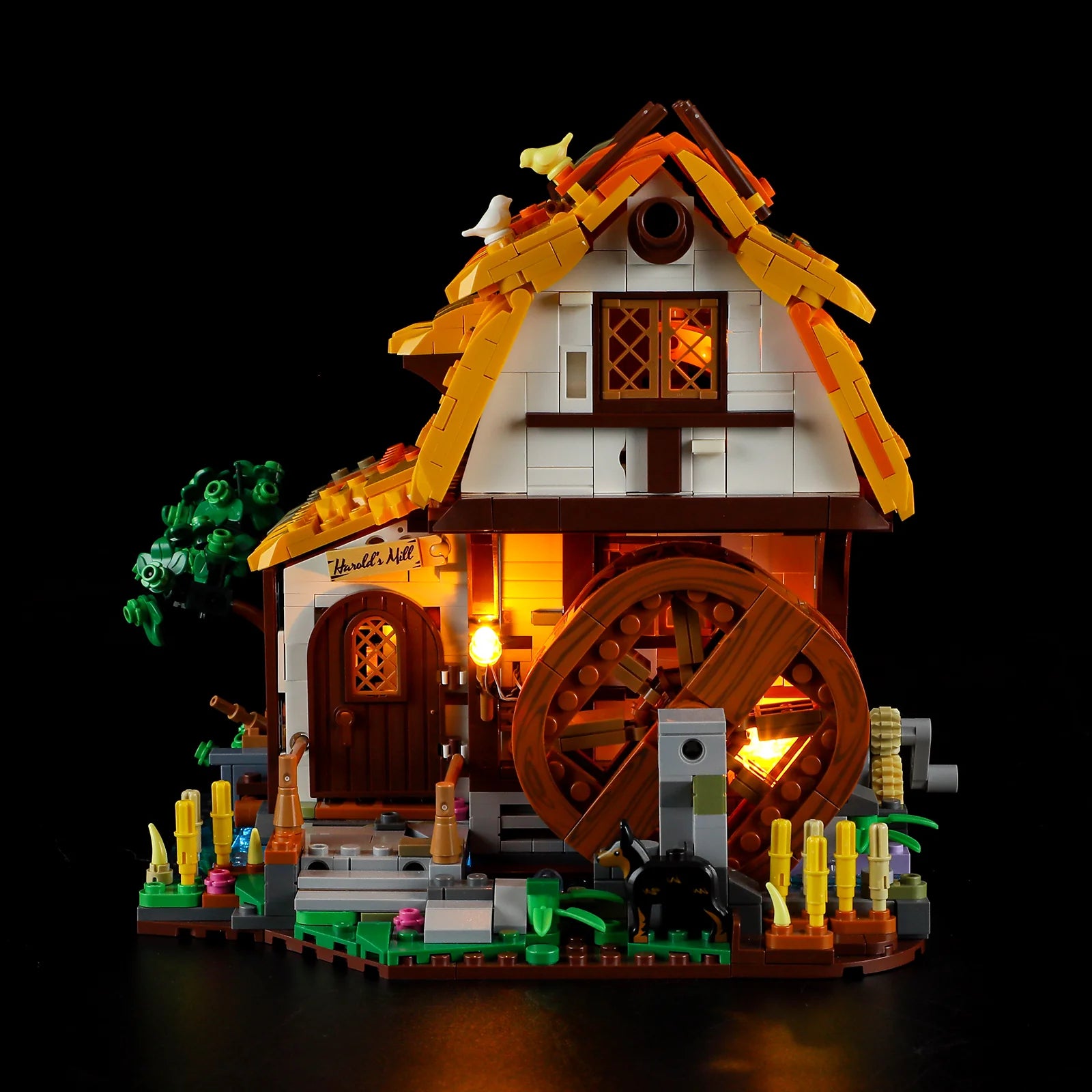 Lumibricks (Formerly Funwhole) F9061 Medieval Water Mill front view at night with glowing waterwheel, minifigures, and countryside details