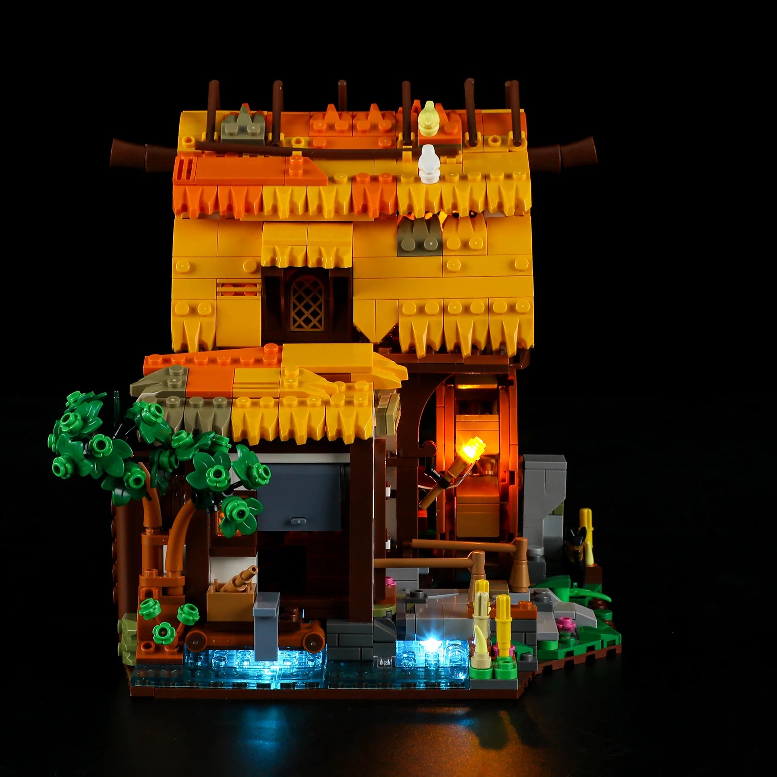 Lumibricks (Formerly Funwhole) F9061 Medieval Water Mill side view at night with illuminated stream, glowing windows, and rustic landscaping