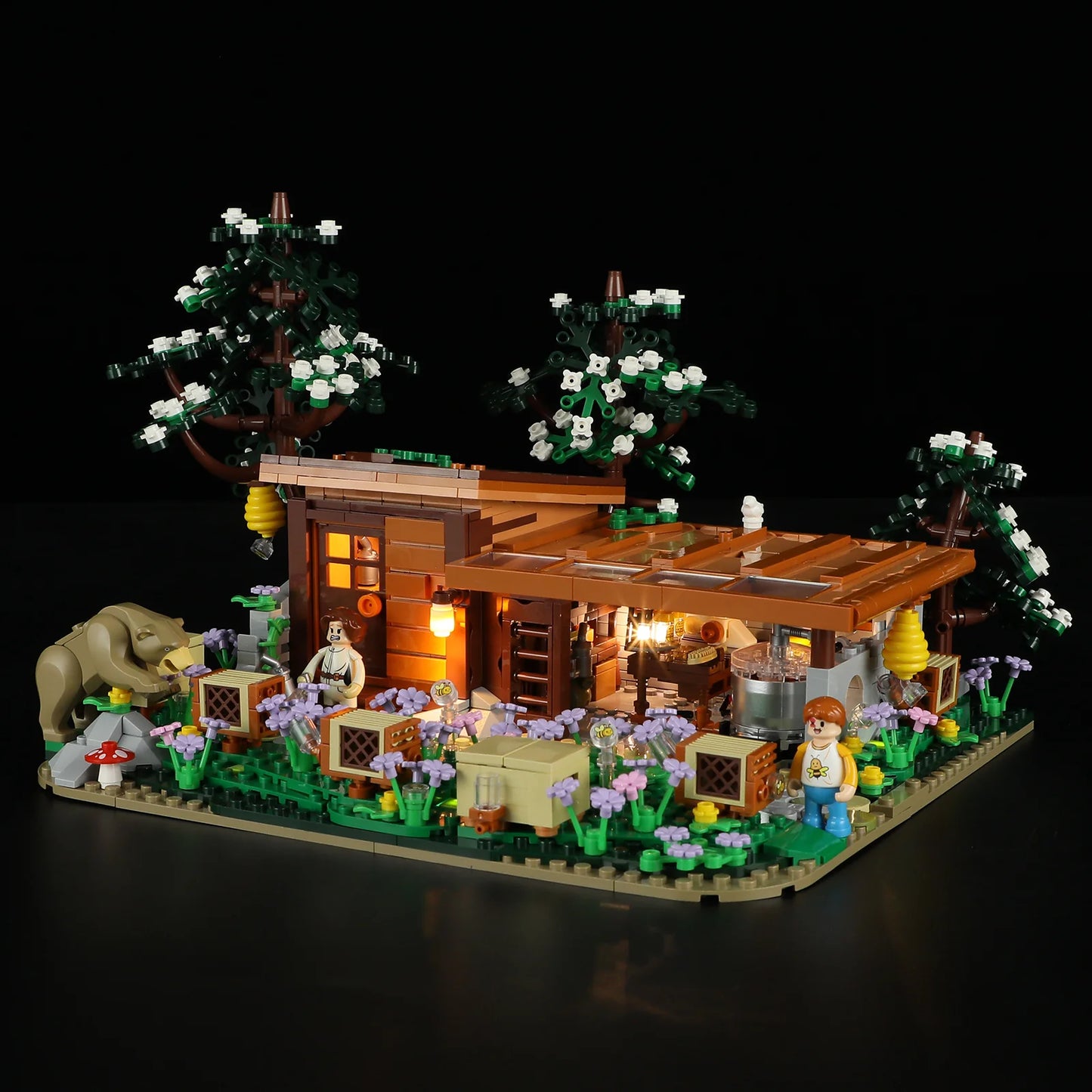 Lumibricks (Formerly Funwhole) F9062 Bee Farm angled night view with glowing lights, bear, minifigures, and detailed apiary