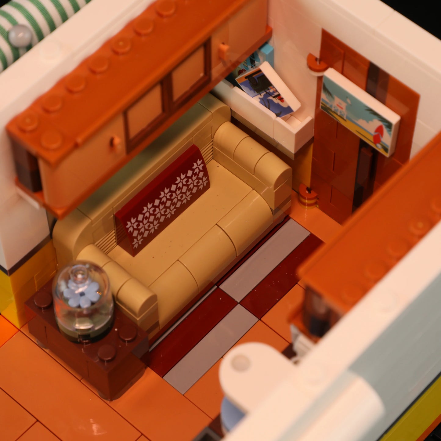 Lumibricks F9032 Travel Trailer living room with tan sofa, patterned pillow, aquarium, and wall art details